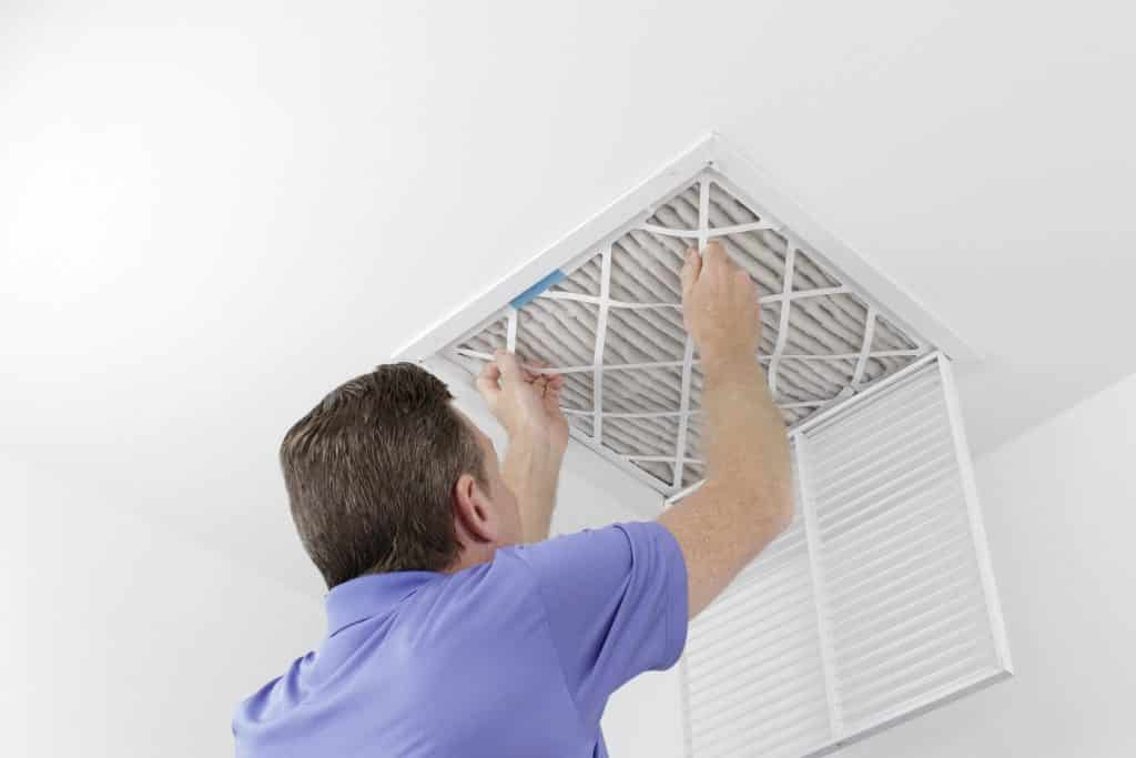 Caucasian Male Removing A Square Pleated Dirty Air Filter With B